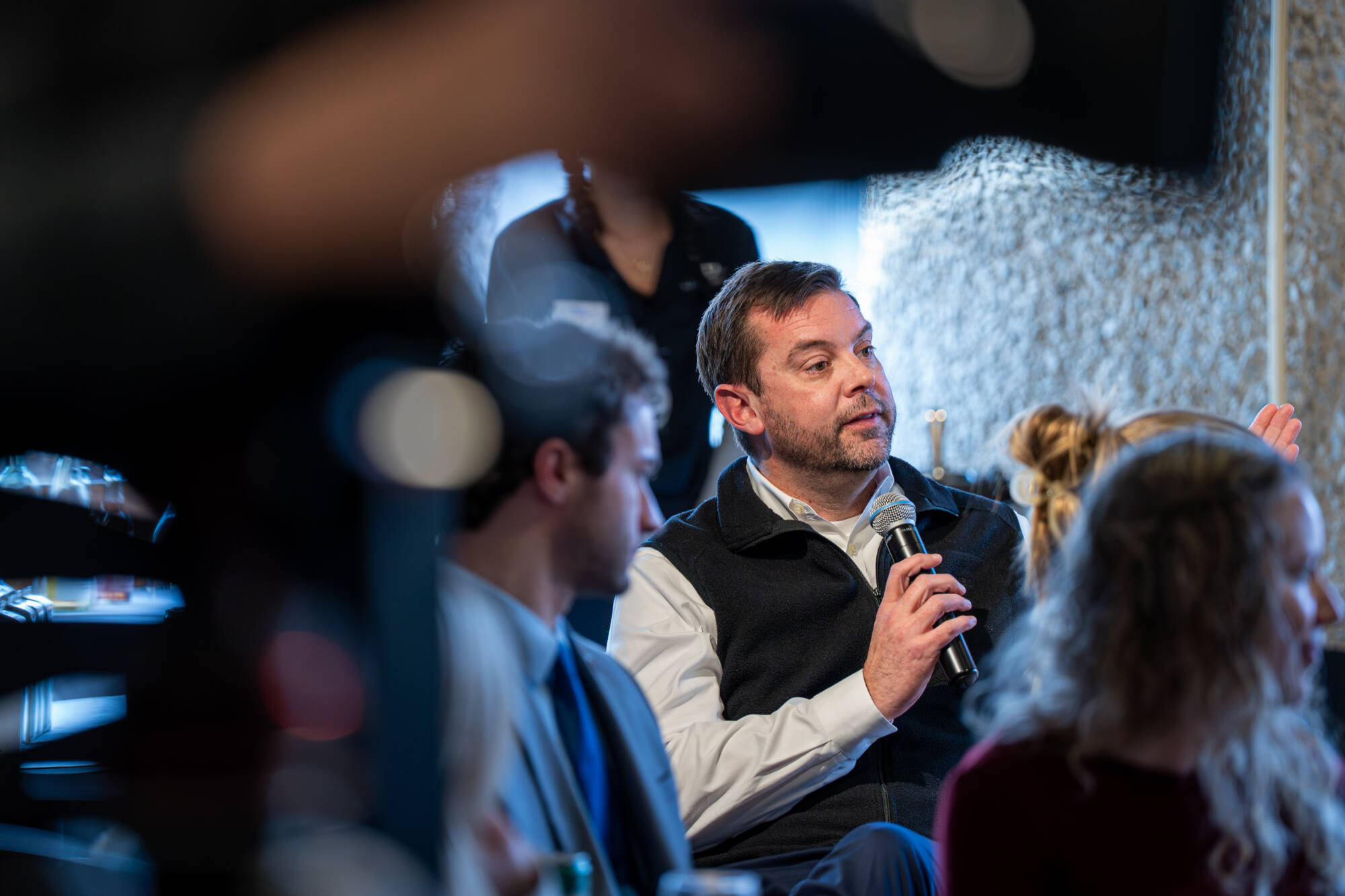 Dr. Ryan Otter asks a question from the crowd during a group meeting.